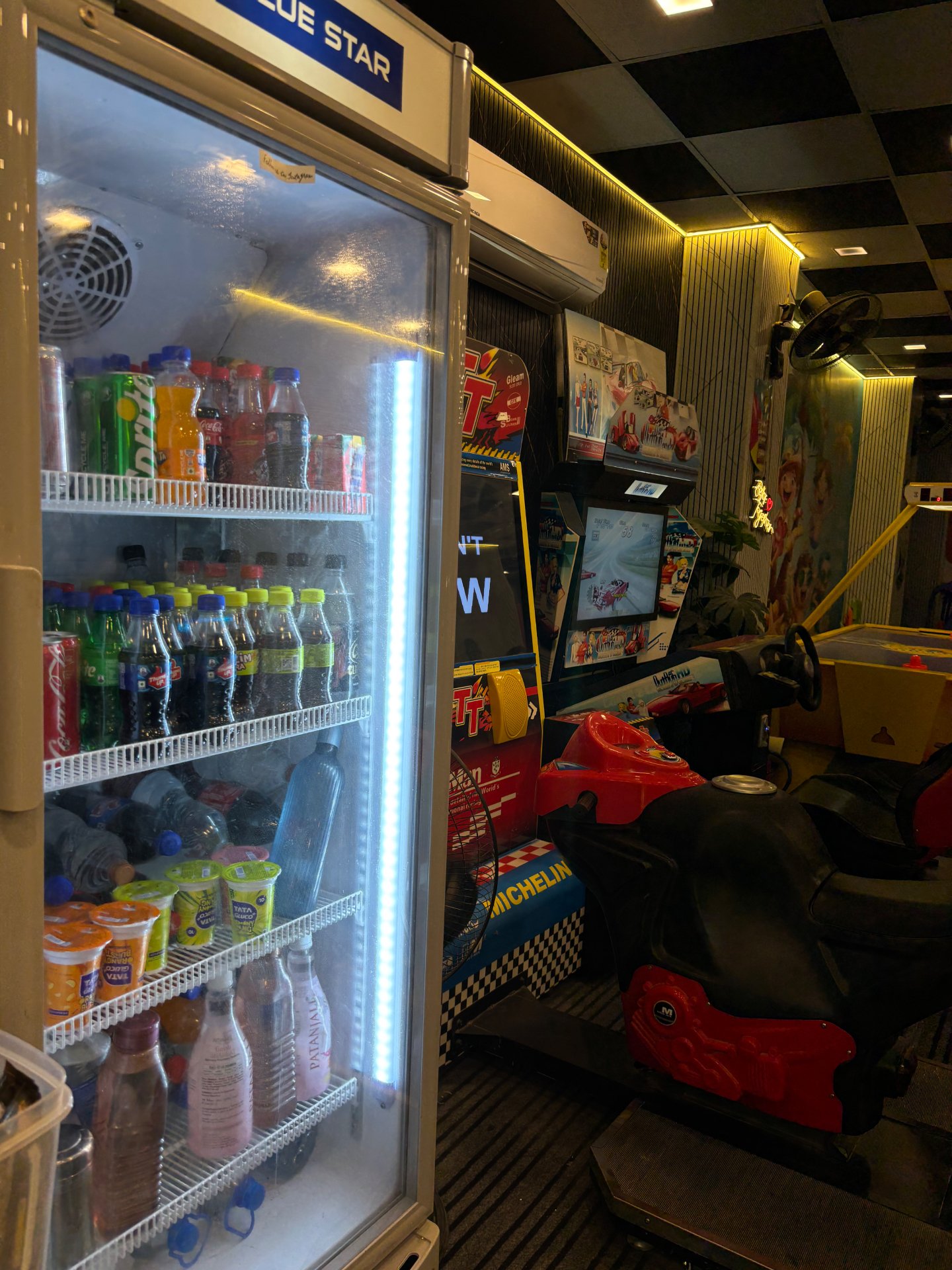 Cold drinks fridge next to racing simulators